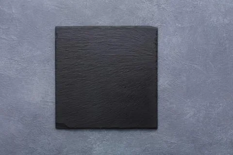 Black square tile on gray textured background Stock Photos