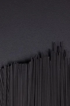 Black squid ink spaghetti creating abstract wavy pattern Stock Photos