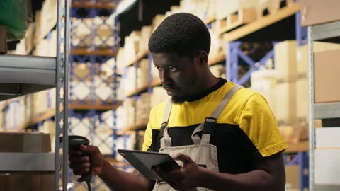 Black staff member using a barcode scanner to process shipping labels Stock Footage 315538449