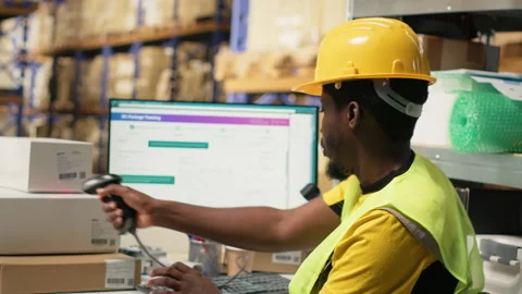 Black staff member using a barcode scanner to process shipping labels Stock Footage 315539537