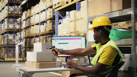 Black staff member using a barcode scanner to process shipping labels Stock Footage 315542932