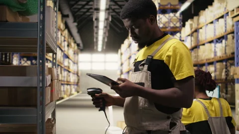 Black staff member using a barcode scanner to process shipping labels Stock Footage 315713389