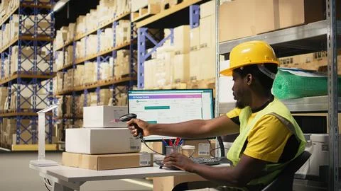 Black staff member using a barcode scanner to process shipping labels Fotos Stock