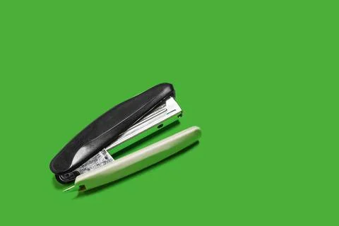 Black stapler isolated on a green background Stock Photos