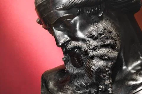Black statue of bearded man face portrait red background Stock Photos