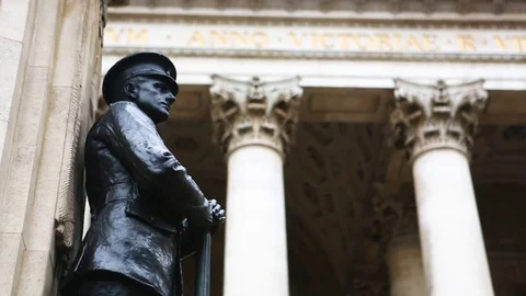 Black statue of a man standing outside a building with pillars in the background Stock Footage 77449516