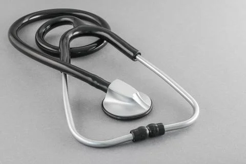 Black stethoscope on a gray background. Stock Photos