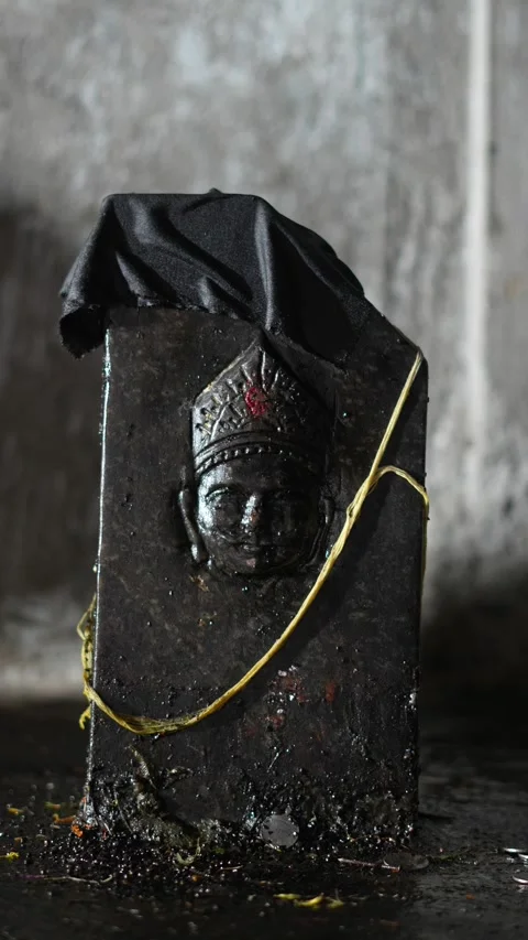 Black Stone Shani Dev Idol Draped with Sacred Cloth in Hindu Temple Setting Stock Footage 326360482
