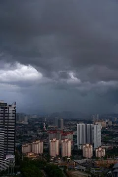 A black storm cloud of rain over the town. Bad weather conditions. Stock Photos