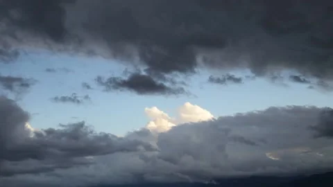 Black storm clouds move fast while blue sky and white cumulus clouds are visible Vídeo Stock 149031096