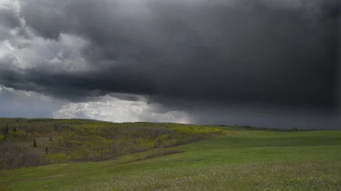 Black storm clouds move in over grass prairie landscape, Alberta, Canada, 4k Stock Footage 276328997