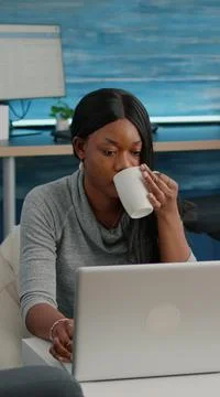Black student drinking coffee typing social media article browsing lecture 스톡 사진