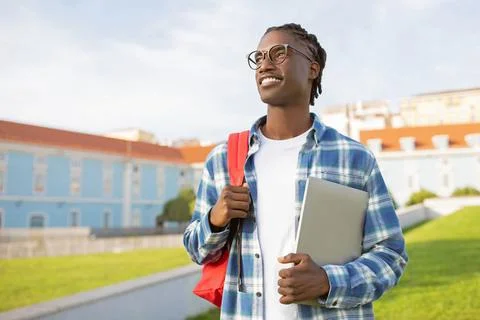 Black Student Guy With Backpack And Laptop Over University Campus Stock Photos
