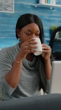 Black student smiling while working at social media blog article typing 스톡 사진