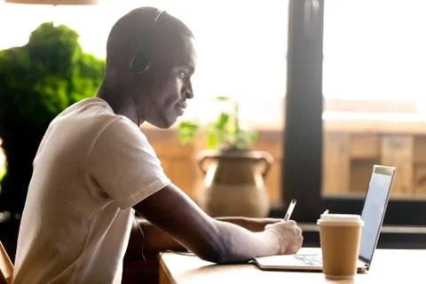 Black student studying using laptop and headphones 写真素材