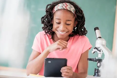 Black student using digital tablet in science class Stock Photos