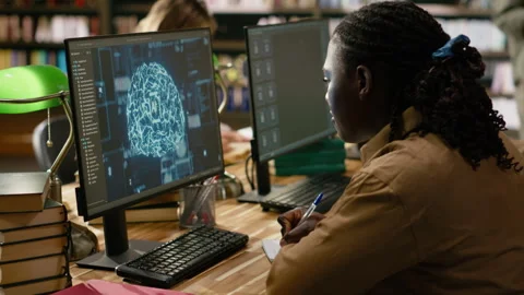 Black student working with AI brain display on desktop computer in library Stock Footage 337231229