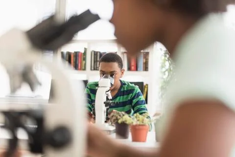 Black students using microscopes in science lab 写真素材