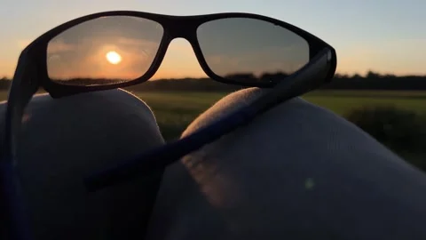 Black Sunglasses on Knees at Sunset Video stock 343340451