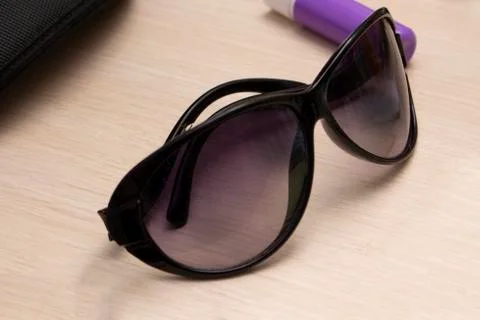Black sunglasses lying on the table close-up Stock Photos