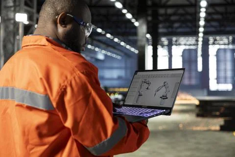 Black supervisor operates automation software to control robot equipment Stock Photos