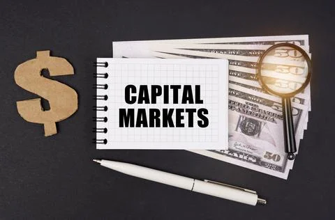On a black surface are dollars, a pen and a notepad with the inscription - CA Stock Photos