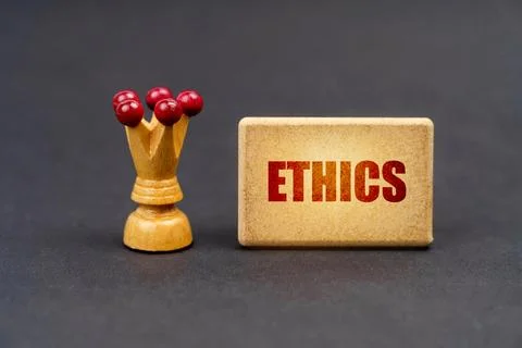 On a black surface there is a chess piece and a wooden block with the inscr.. Foto stock