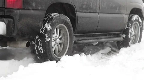 Black SUV backing up in the snow. Close up. Stock Footage 33842376