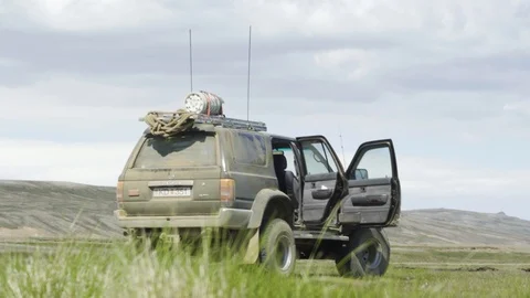Black SUV de-dusting in nature, up in the mountains after off-road Stock Footage 112577253