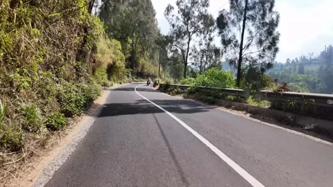 Black SUV drives winding mountain road Видео 345139638