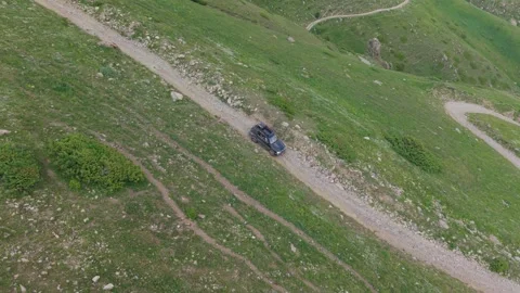 Black suv driving uphill on a mountain dirt road Video stock 312450912