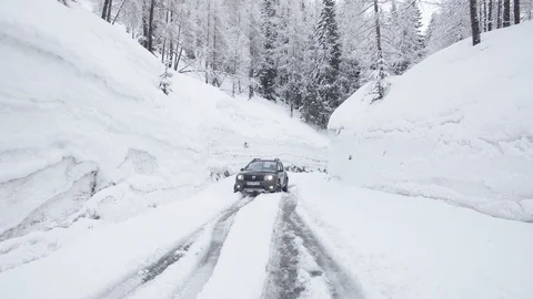 A black suv stuck in snow surrounded by a wall of ice Stock Footage 103222953