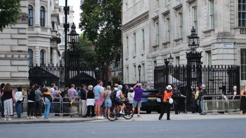 Black SUV turns into the Gates of Downing Street as visitors stand behind Stock Footage 345812277