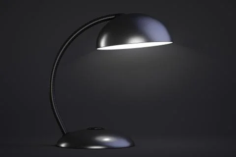 The black table lamp is on. Dark background. Foto stock