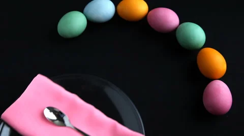 On a black table next to the eggs put a plate, napkin and Easter cake. Stock Footage 61750120