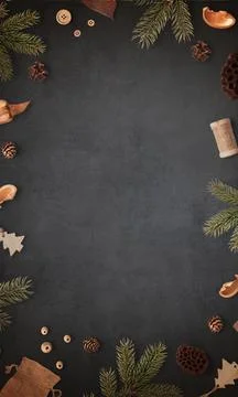 Black table surrounded by Christmas tree branches and traditional holiday dec Stock Photos