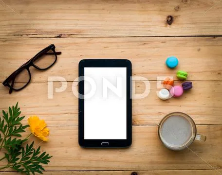 Black tablet with hot coffee and colorful sweet on wooden table in warm tone Stock Photos