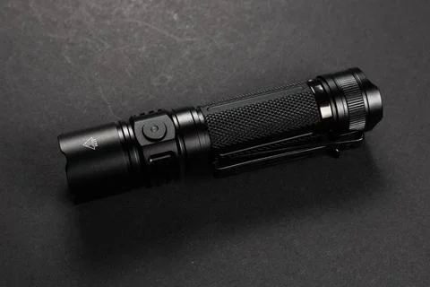 Black tactical flashlight on dark background Stockfoto's
