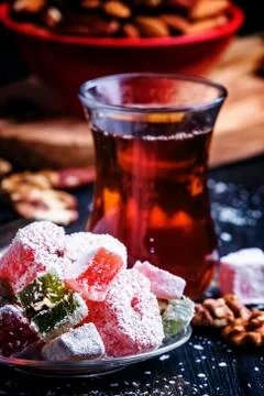 Black tea and candy with nuts on a dark background, selective focus Stock Photos