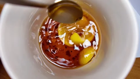 Black tea and lemon slow motion video. tea in a cup. lemon floating in a cu.. Stock Footage 303428514
