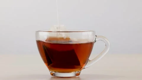 Black Tea Bag Steeping in Transparent Glass Cup Stock Footage 341732986