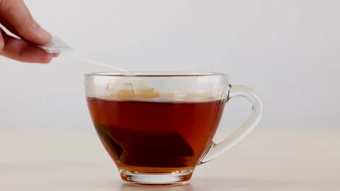 Black Tea Bag Steeping in Transparent Glass Cup Stock Footage 341905476