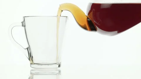 Black tea being poured into tea cup on a white background Stock Footage 96685501