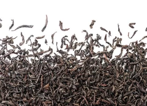 Black tea close up scattered on a white isolated. The view from top Stock Photos