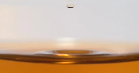 Black tea droplet falling into tea creating splash in super slow motion Stock Footage 345976682