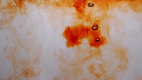 Black tea drops falling underwater in slow motion. Closeup of orange color paint Stock Footage 211583931