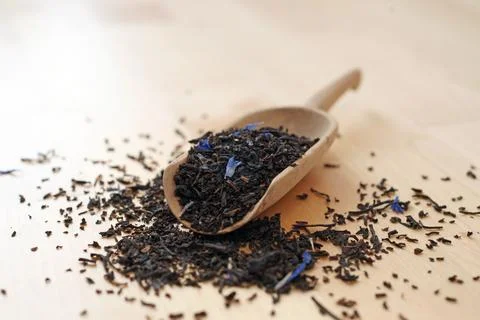 Black tea Earl Grey Ceylon Darjeeling on wooden shovel scoop closeup Stock Photos