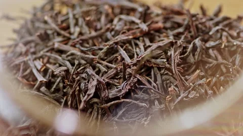 Black tea leaves are falling into the teapot close up. Stock Footage 132222982