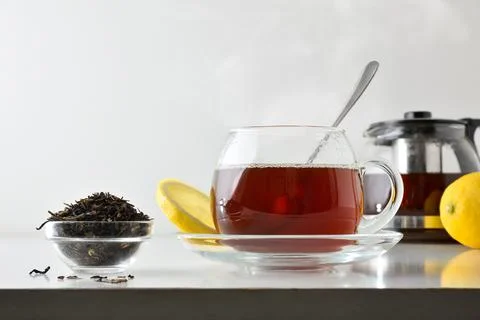 Black tea with lemon on white table isolated front view Stock Photos