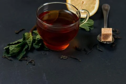 Black tea with mint and lemon on a dark background with copy space Stock Photos